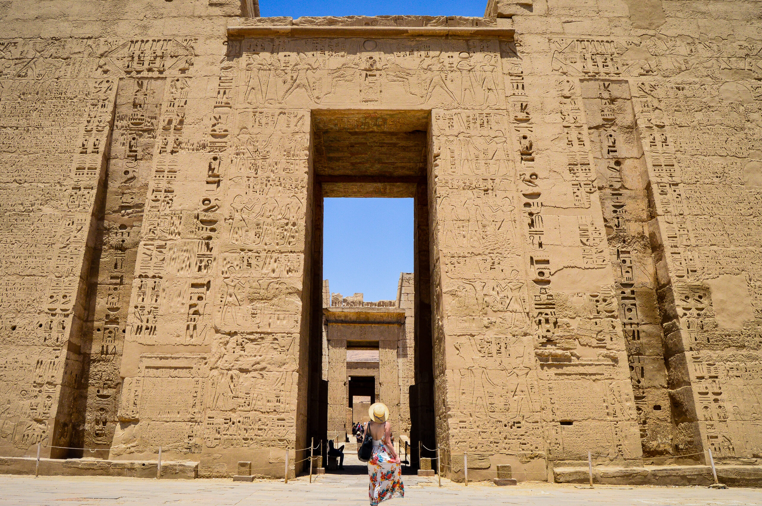 closeup shot female standing front medinet habu temple egypt 2 scaled